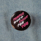 A black circular pin with text that says "people don't exist for you" in pink and white bubble letters.