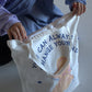 Two hands unzipping the opening of the tote.